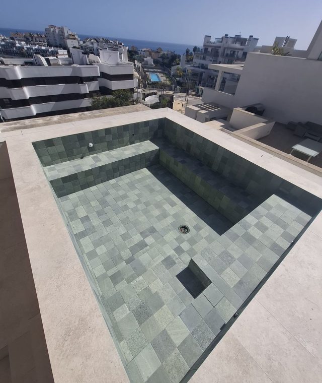 Piscina en atico con borde porcelanico y revestimiento verde